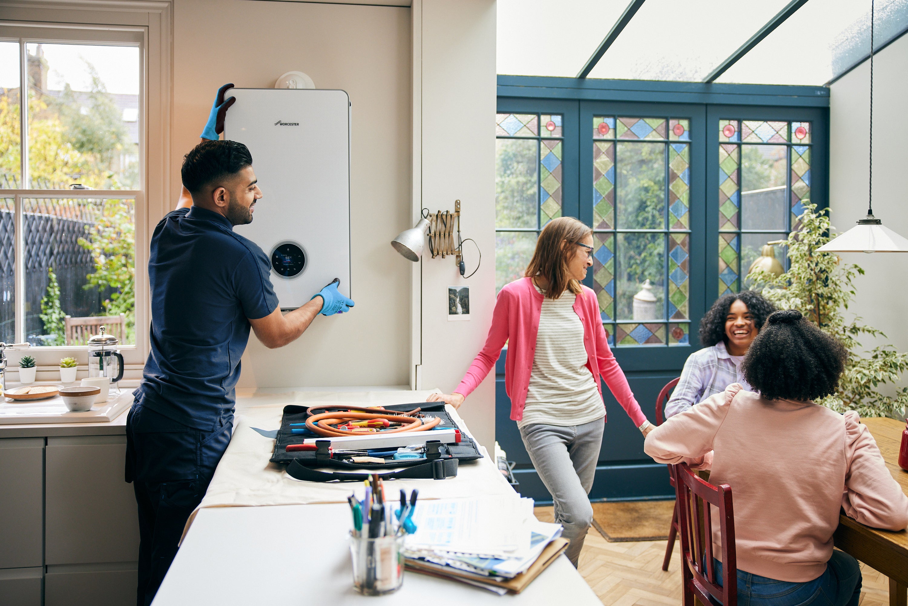 Engineer fixing boiler in kitchen
